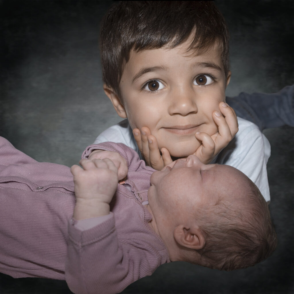 Léon, frère attentionné, couve sa sœur Adèle, poupon encore rose. Bilirit-photographie